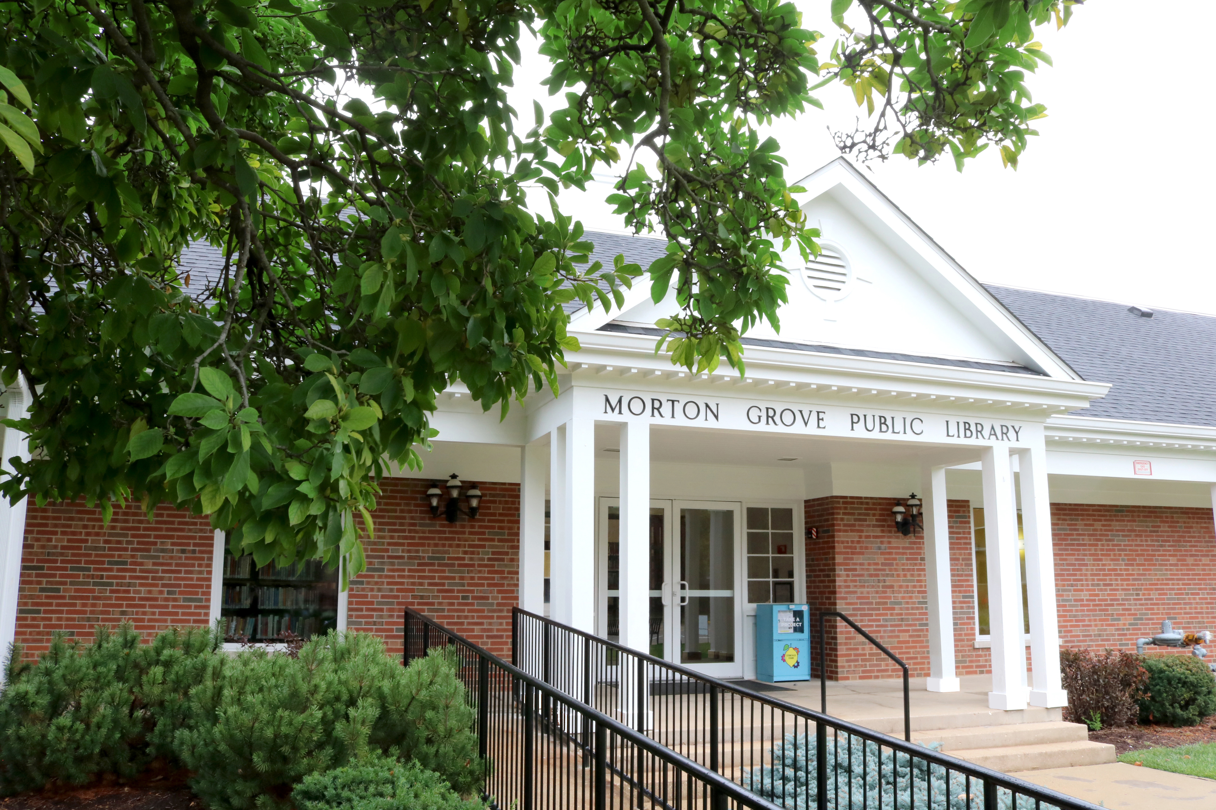 the front of the library building with white columns and white triangular structure and red bricks