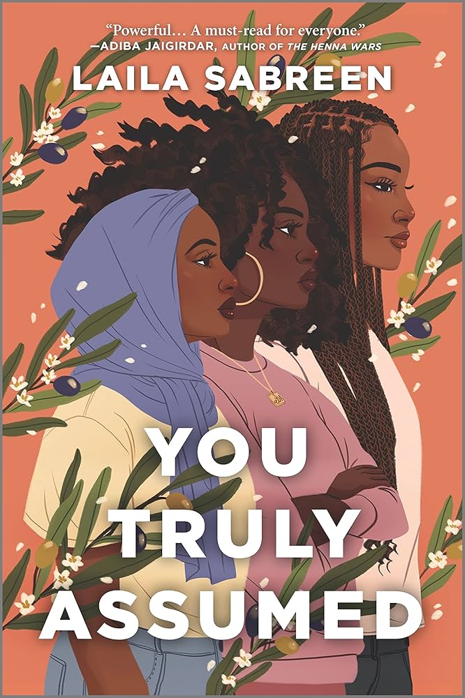 Book cover for You Truly Assumed by Laila Sabreen. Three young Black women are shown in side profile against a warm orange background, framed by leafy branches with small white blossoms and olives.