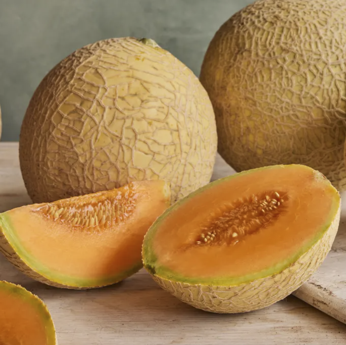 cantaloupe fruit sliced and whole on a table