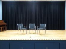 Three chairs on empty stage